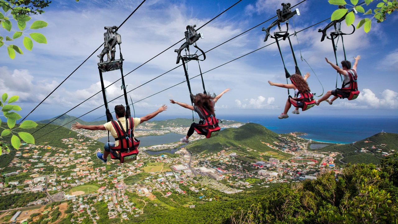 Riders enjoying the Sky Explorer chairlift with panoramic views of St. Maarten before the Flying Dutchman zipline adventure.