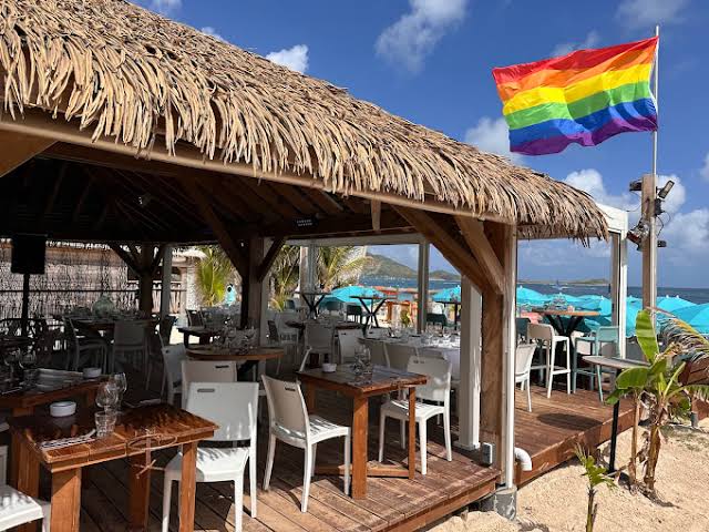 Aloha Beach Bar at Orient Bay displaying a rainbow Pride flag