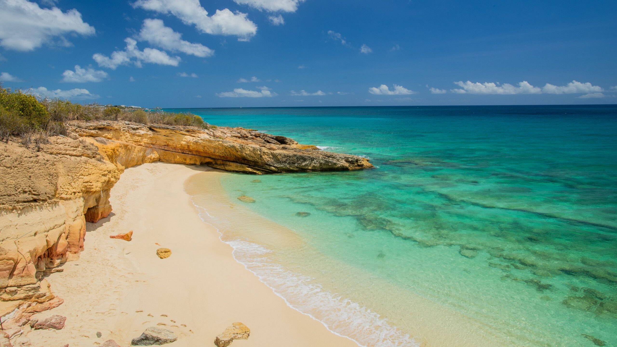 Golden limestone cliffs and turquoise Caribbean water at Cupecoy Beach
