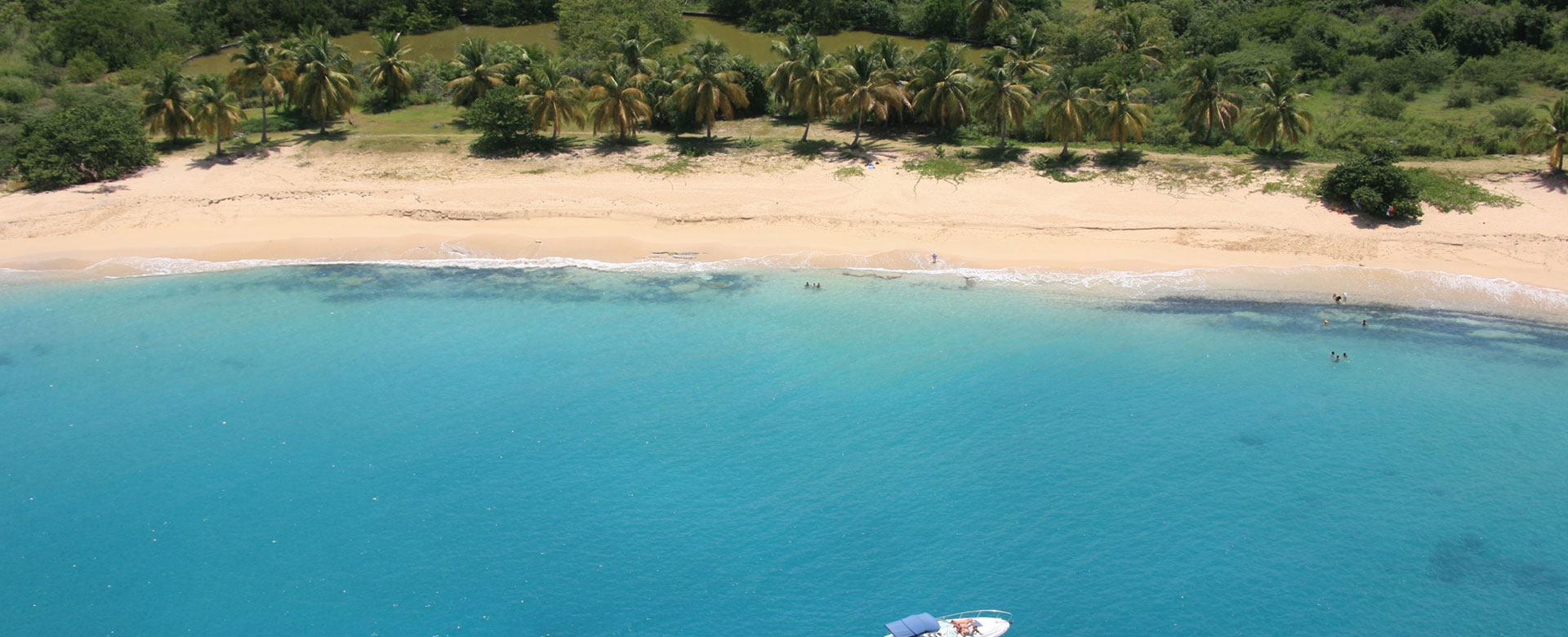 Secluded Happy Bay Beach surrounded by tropical greenery